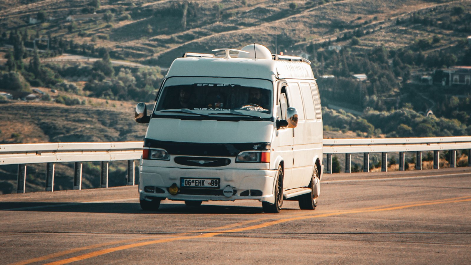 Van blanca de pasajeros circulando por una carretera