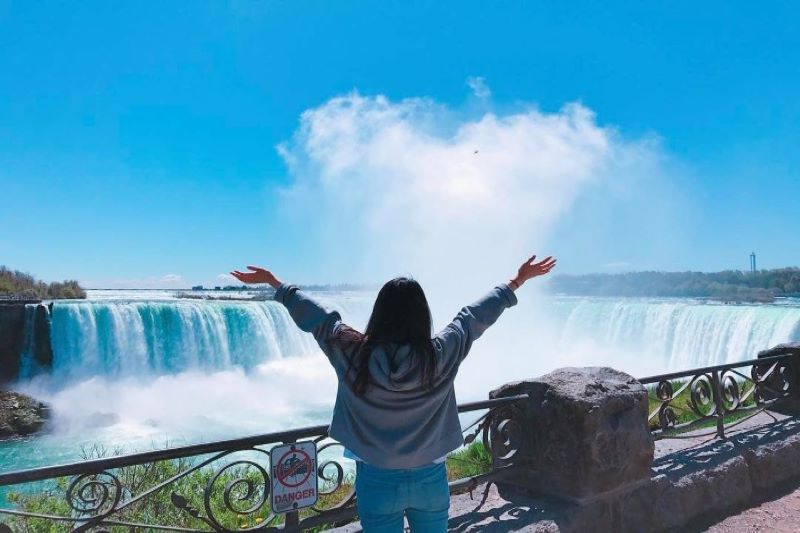 Viajera de espaldas frente a las cataratas del Niágara