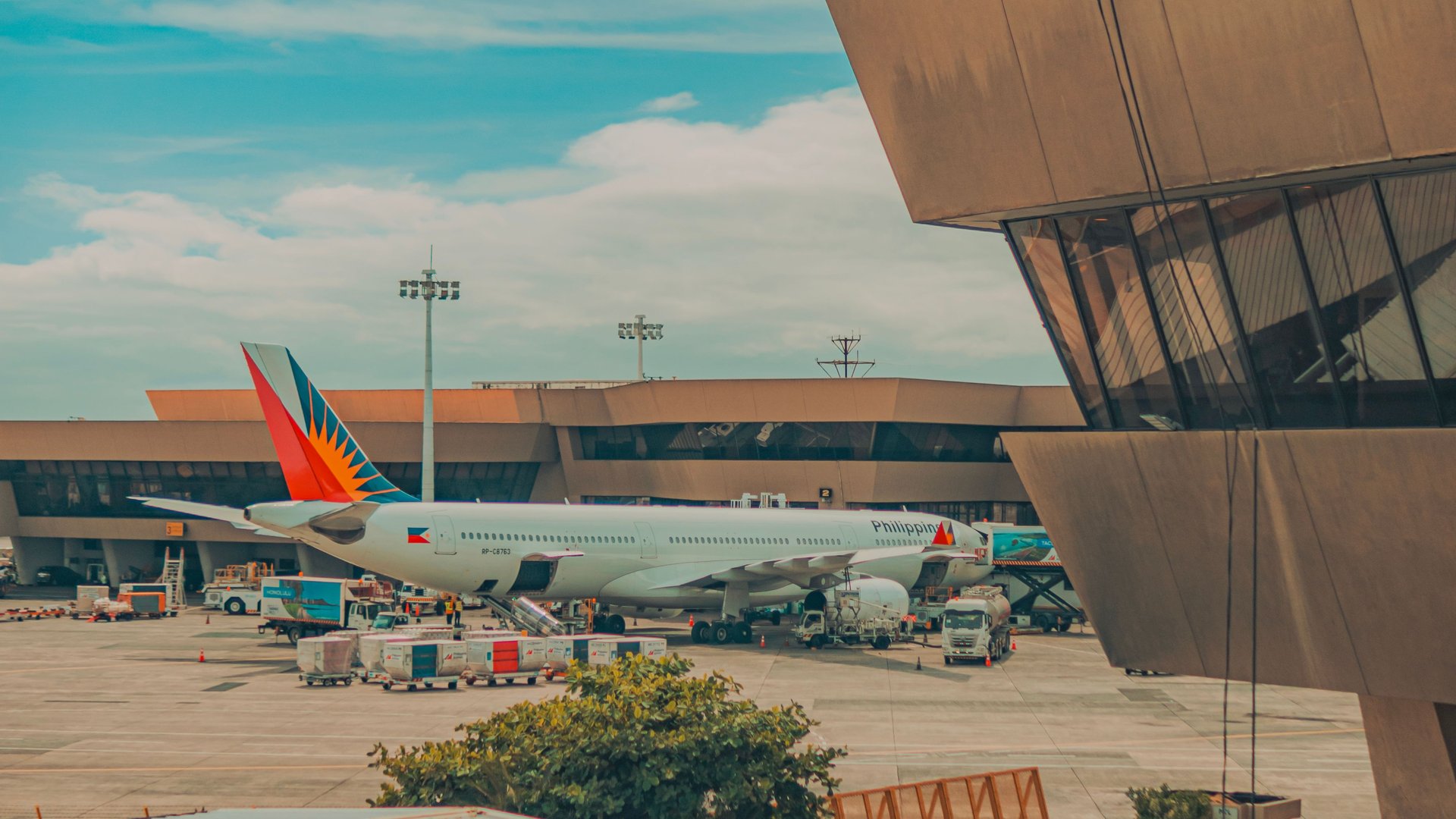 Avión comercial estacionado junto a una terminal de aeropuerto