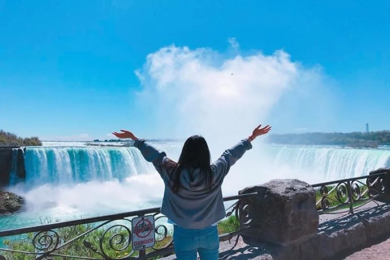 Viajera de espaldas frente a las cataratas del Niágara