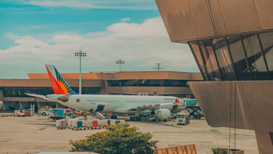 Avión comercial estacionado junto a una terminal de aeropuerto